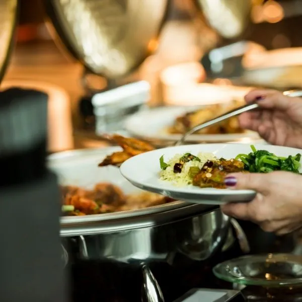 Hand serving rice and vegetables from a buffet station at Hibachi Catering 4 U, a Chinese restaurant in Anselmo